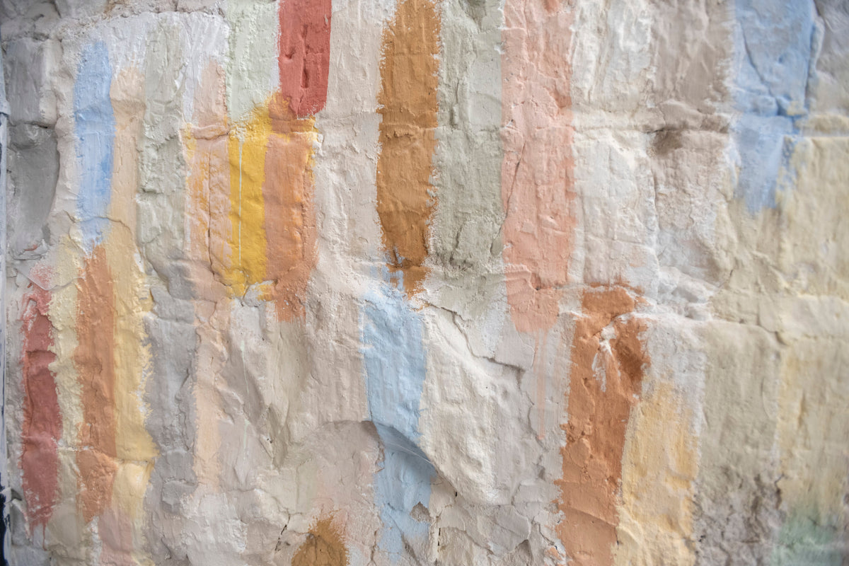 Decorative painted surface showing layered traditional paint colours and textures