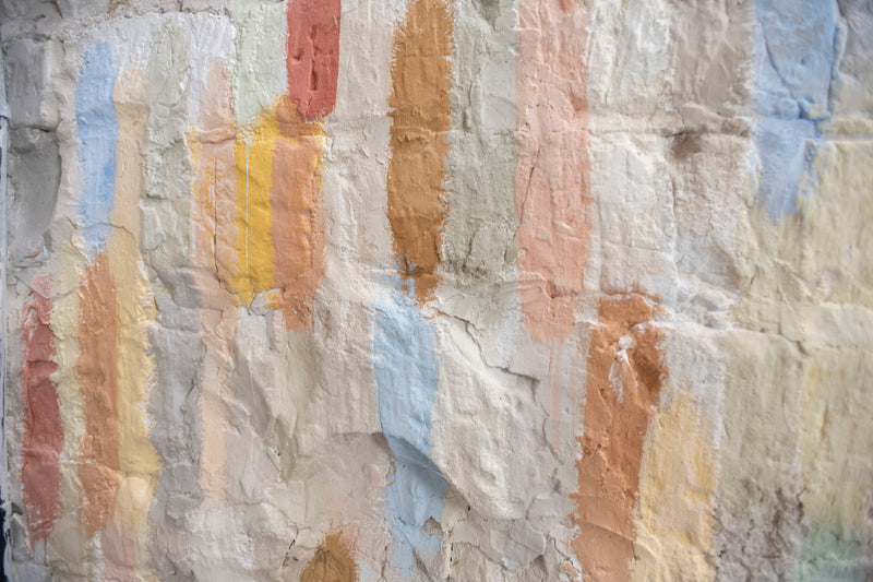 Decorative painted surface showing layered traditional paint colours and textures
