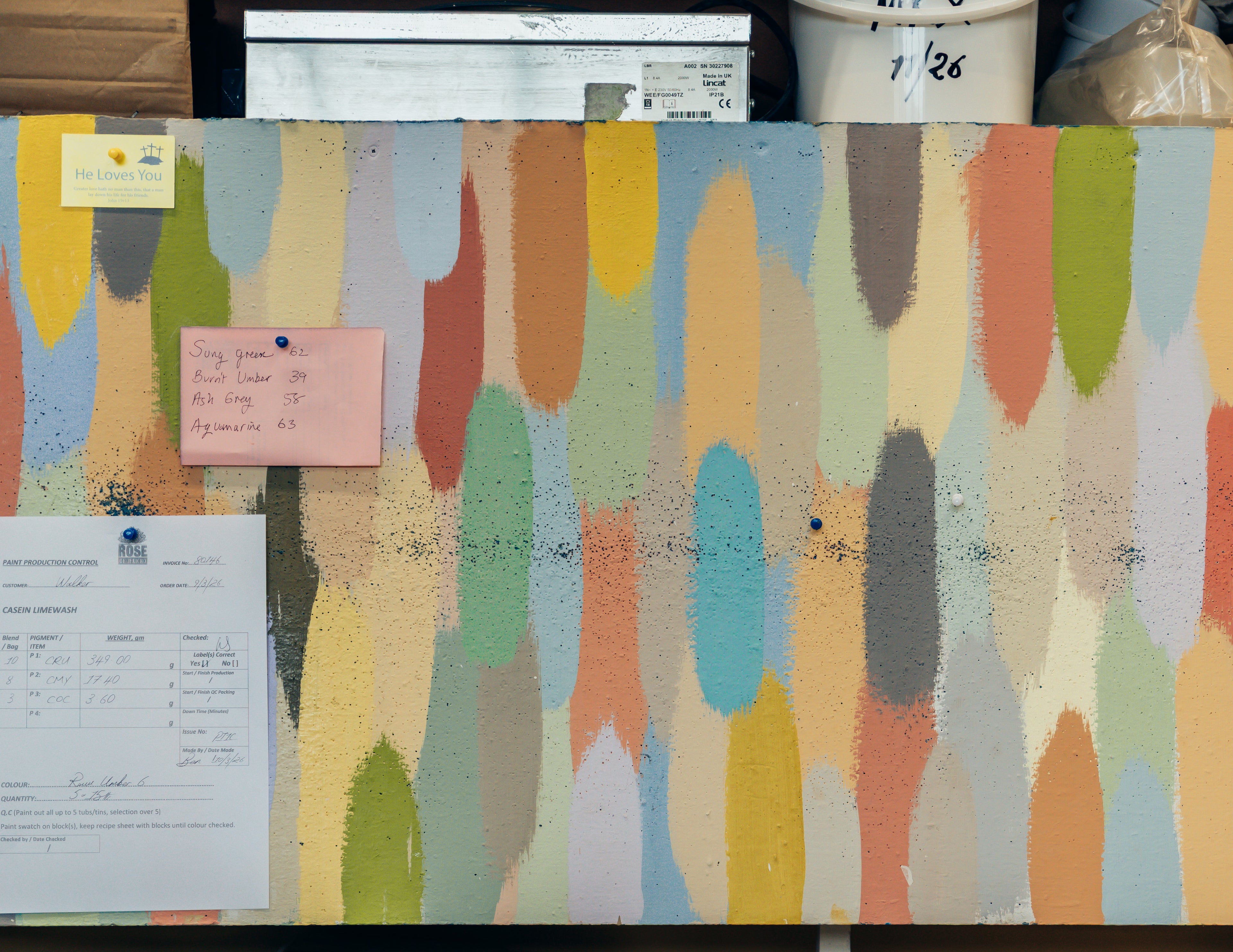Colorful abstract patterned wall with a whiteboard and papers attached.
