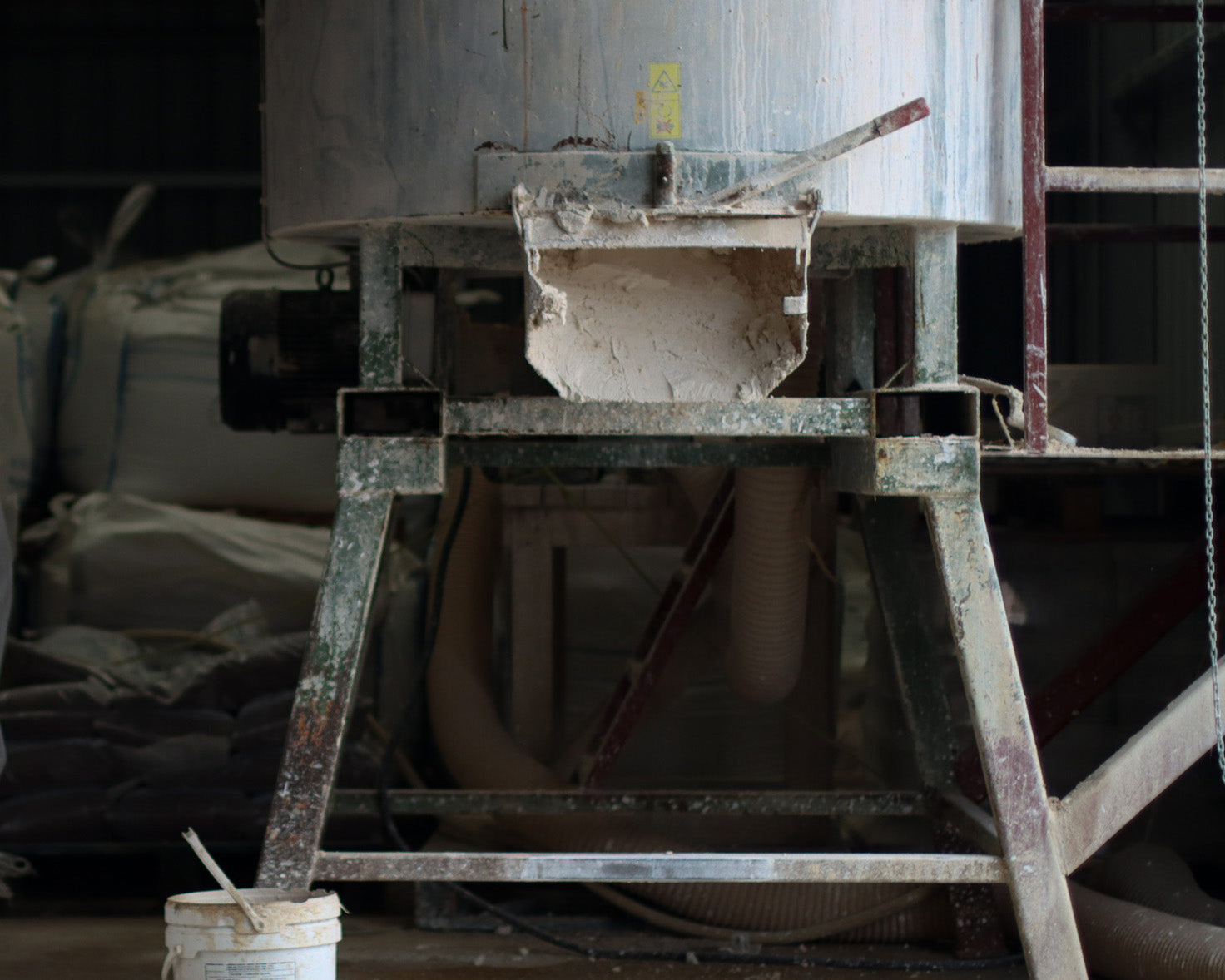Metal stand with a concrete block on top, in an industrial setting